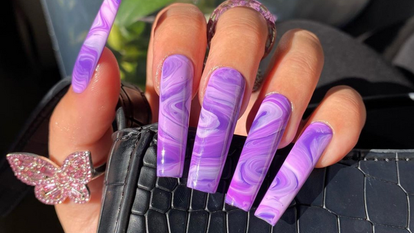 purple acrylic nails with a marble design