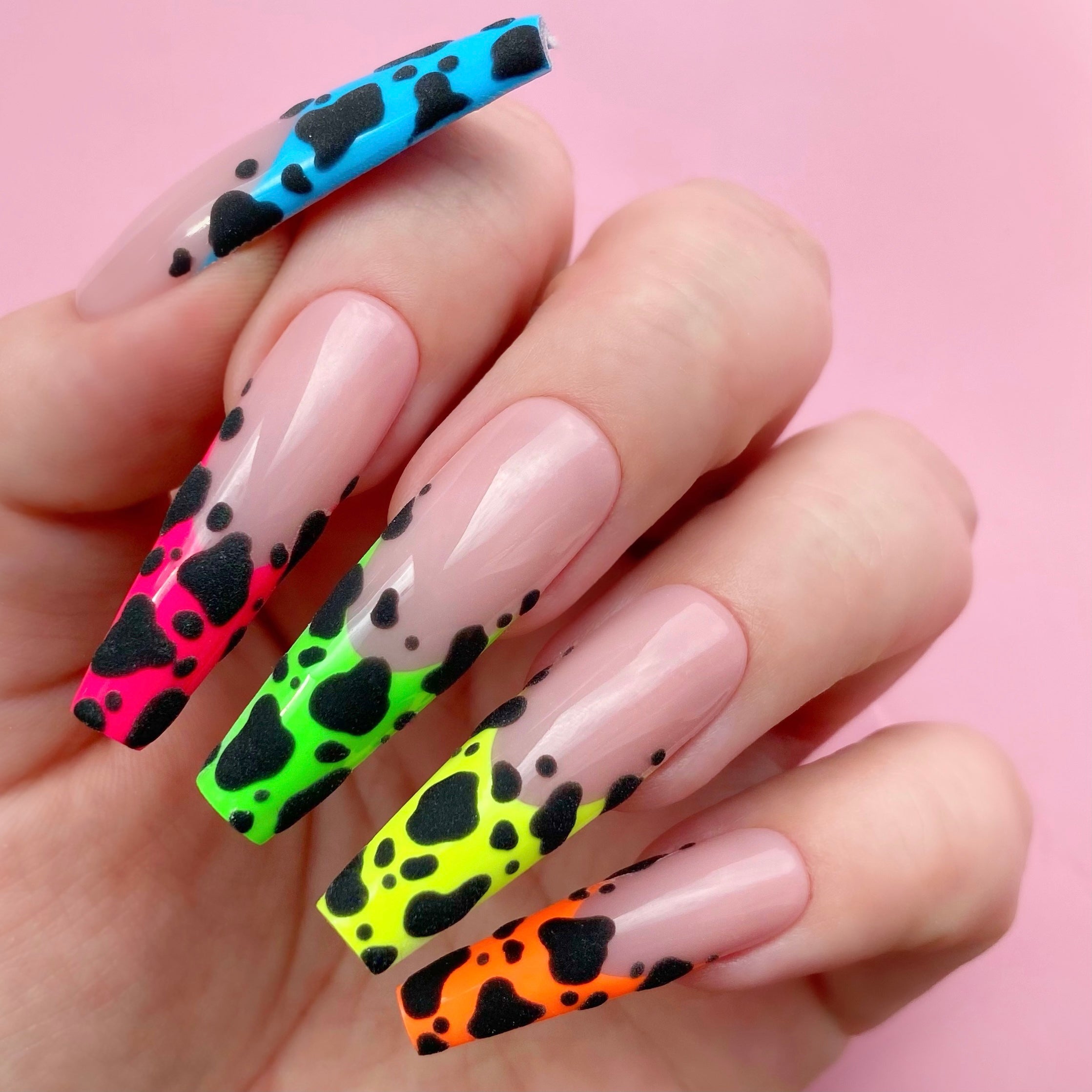 Negative Space gel art applied to nail extensions with cow print design